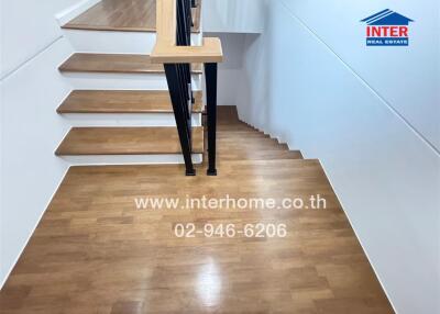 Modern staircase with wooden steps and black metal railing in a residential home