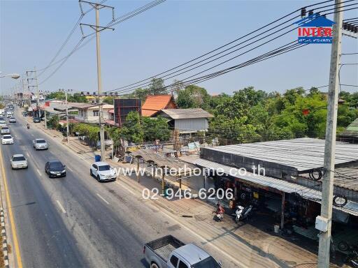 Busy urban street with mixed residential and commercial buildings