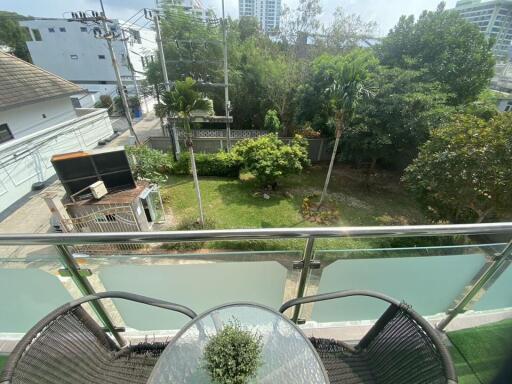 View from balcony overlooking lush garden and urban setting