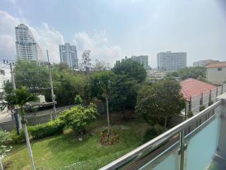 Spacious outdoor view from balcony showcasing greenery and urban skyline