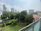 Spacious outdoor view from balcony showcasing greenery and urban skyline