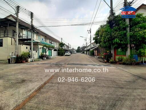 Street view of a residential area with townhouses and clear skies