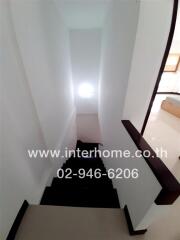 Modern white staircase with wooden handrails leading downstairs