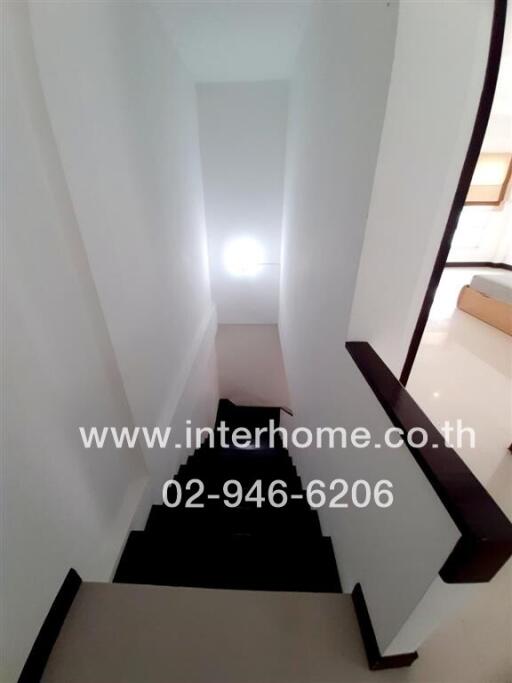 Modern white staircase with wooden handrails leading downstairs