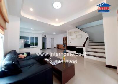 Spacious modern living room with large sofa and staircase
