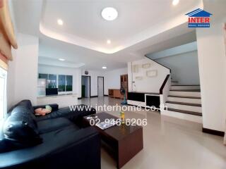 Spacious modern living room with large sofa and staircase