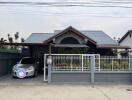 Modern residential house with carport and gated entrance