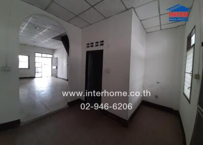 Spacious unfurnished interior of a building with white walls and tile flooring