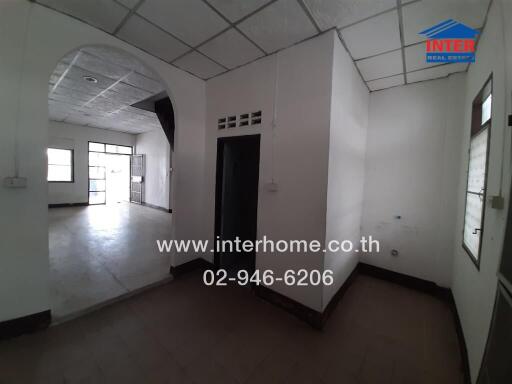 Spacious unfurnished interior of a building with white walls and tile flooring