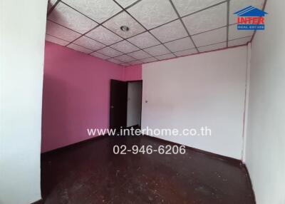 Empty bedroom with pink walls and dark wooden floor