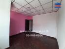 Empty bedroom with pink walls and dark wooden floor