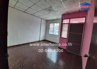 Spacious unfurnished room with large windows and pink door