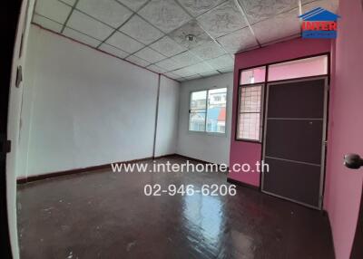 Empty spacious room with pink door and patterned ceiling