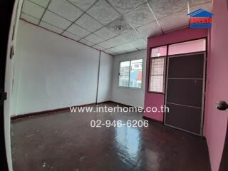 Empty spacious room with pink door and patterned ceiling