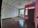 Empty spacious room with pink door and patterned ceiling