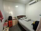 Compact bedroom with single bed and air conditioning unit