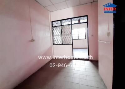 Spacious empty room with pink walls and large window