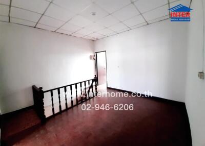 Spacious empty living room with wooden flooring and balcony access