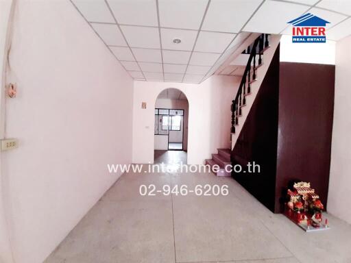 Spacious hallway with staircase and bright lighting