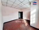 Empty room with hardwood flooring and suspended ceiling