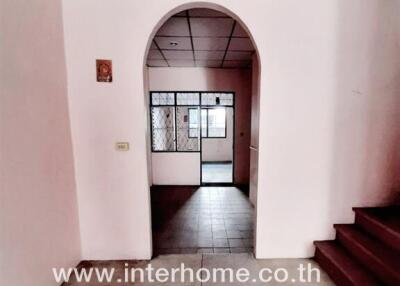 Spacious entrance hall leading to the main door of the house with visible staircase and tiled flooring