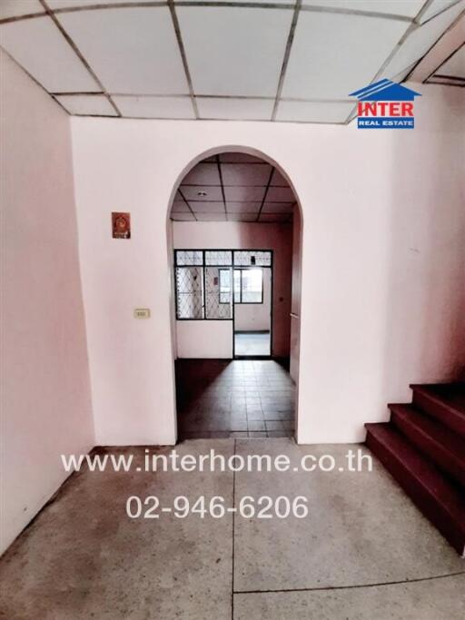 Spacious entrance hall leading to the main door of the house with visible staircase and tiled flooring