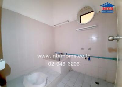 Spacious bathroom in need of renovation with white walls and fixtures