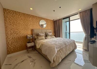 Spacious bedroom with ocean view, featuring a large bed and modern decor