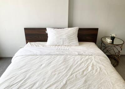 Clean and minimalist bedroom with white bedding and wooden headboard