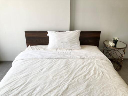 Clean and minimalist bedroom with white bedding and wooden headboard