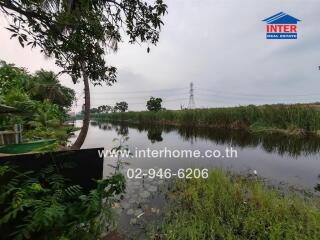 Tranquil riverside view with lush greenery and walking path