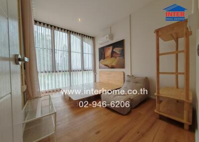 Bright and well-furnished bedroom with large windows and wooden flooring