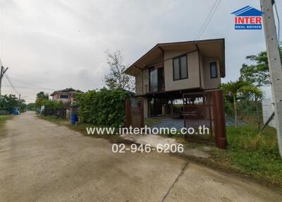 Exterior view of a modern elevated house with surrounding fence