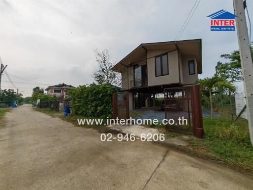 Exterior view of a modern elevated house with surrounding fence