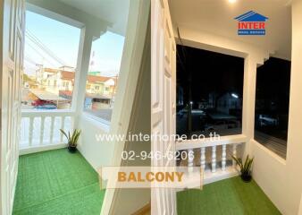 Spacious balcony with artificial grass and a view of the neighborhood