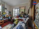 Cluttered living room with large windows and traditional decor