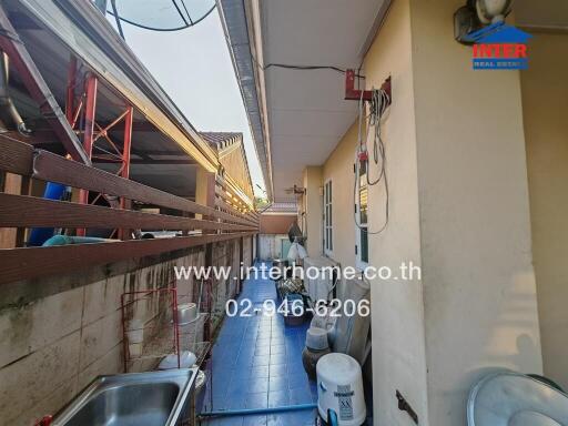 Outdoor utility area beside a building with washing facilities and storage