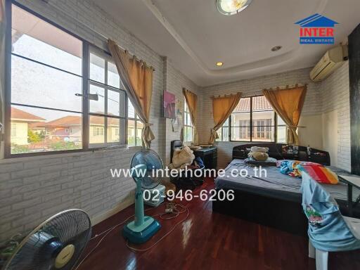 Spacious bedroom with stone accent wall and large windows