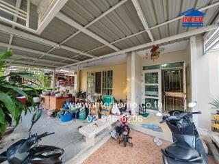 Exterior view of a house with covered patio and parked scooters