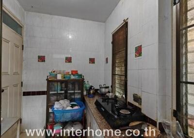 Compact kitchen with tiled walls and various appliances