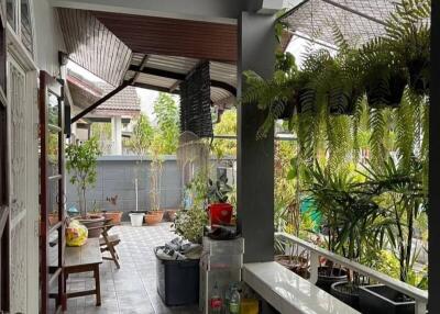 Spacious covered porch area with seating and lush greenery