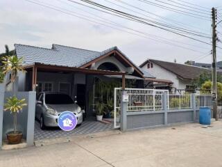 Exterior view of a modern single-family home with carport and gated entrance