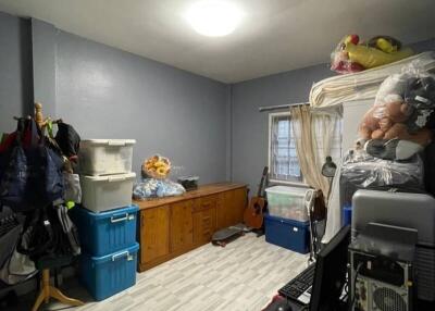 Cluttered bedroom with storage boxes and personal items