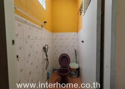 Narrow bathroom with tiled walls and essential fixtures
