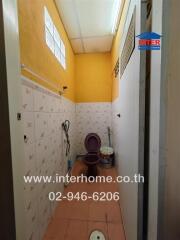Narrow bathroom with tiled walls and essential fixtures