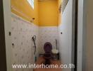 Narrow bathroom with tiled walls and essential fixtures