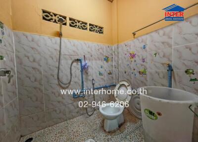 Compact tiled bathroom with toilet and shower