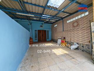 Spacious covered outdoor area with brick walls and tiled floor