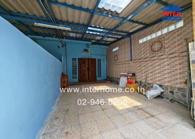 Spacious covered outdoor area with brick walls and tiled floor