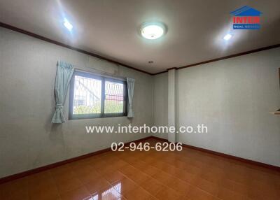 Spacious and well-lit empty living room with large window and tiled floor